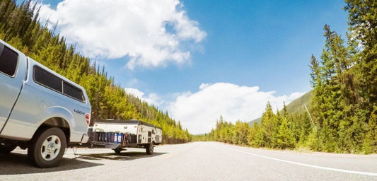 Photo of a road track with car on the sides are of the trees