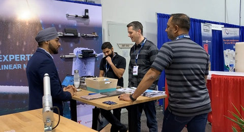 Photo of four men communicating at the ATX West show in USA